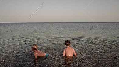 Two toddler boys enjoying summer holidays in the sea