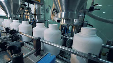 Factory machines filling plastic bottles, automatic process.