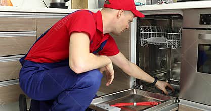 Home appliance maintenance service - repairman working with dishwasher