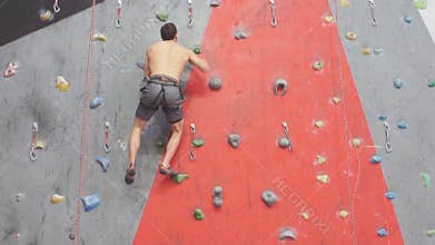 Strong man enjoying rock climbing, slow motion