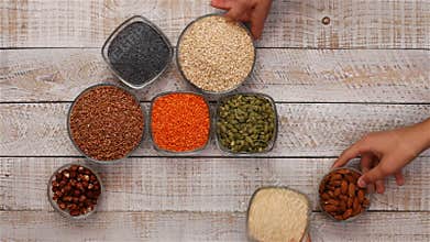 Hands slide in whole grains in bowls diversified diet concept