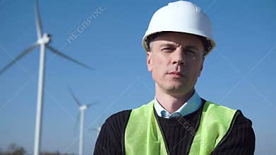 Thoughful engineer against wind turbine