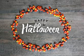 Happy Halloween Calligraphy With Candy Corn Oval Border Over Rustic Wooden Background, Horizontal