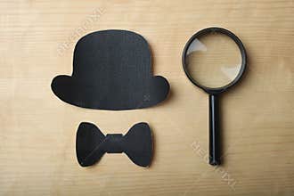 Magnifying glass, a black hat and a butterfly