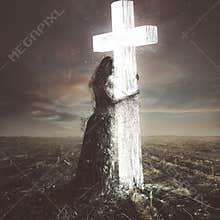 Woman made of dirt clings to the cross