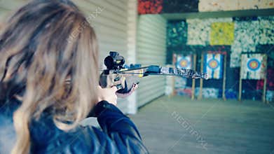 The blonde girl takes aim the crossbow