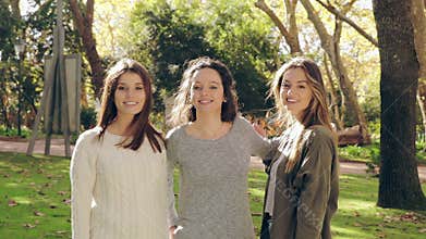 Girls in the park hugging and smiling