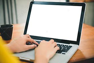 Woman hands typing laptop computer with blank screen on table in coffee shop.