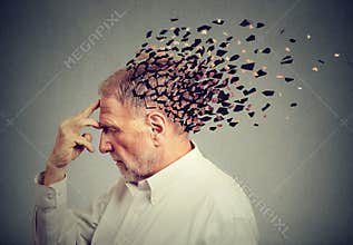 Memory loss due to dementia. Senior man losing parts of head as sign of decreased mind function.