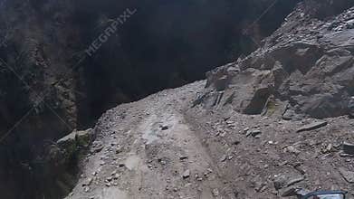 A motorcyclist rides on a dangerous mountain road