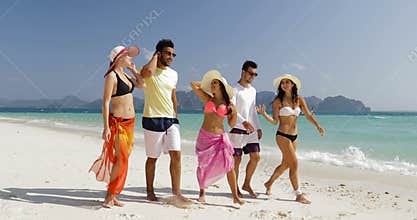 People walking on beach talking, men and women communication tourists group on summer holiday