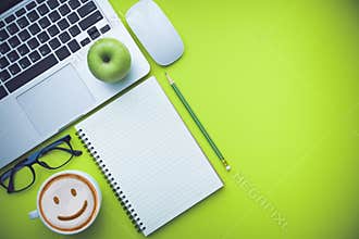 Office desk table with laptop and supplies.