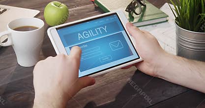 Looking at agility internet page using digital tablet at desk