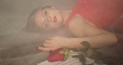A dying brunette girl lies in a smoke on the floor.