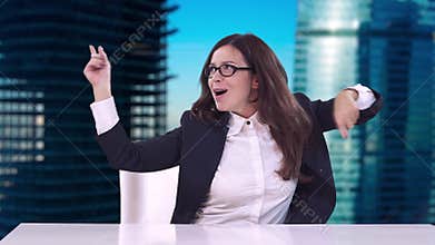Beautiful brunette with glasses sitting in a business suit at office Desk and enjoys a successful career