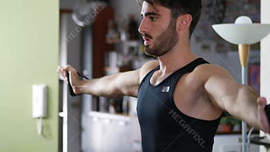 Young man exercising at home with elastic bands