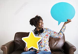 Happy African American holding copyspace speech bubble and a star sign