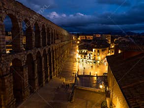 Segovia, Spain at the ancient Roman aqueduct. The Aqueduct of Segovia, located in Plaza del Azoguejo, is the defining historical f