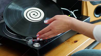 Woman turns off the turntable takes the LP