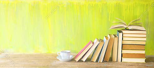 Row of old books and a cup of coffee on a rustic book shelf.