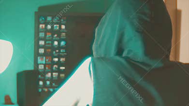 Hacker man programmer in the hood using computer for hack information and data from user account. teal orange color
