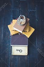 A stack of books, a lock and a key lie on the floor