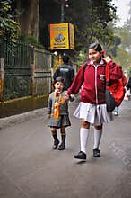 DARJEELING INDIA - APRIL 2012 : Older sister holding hand younger sister on the way to school in Darjeeling, India as of April 12,