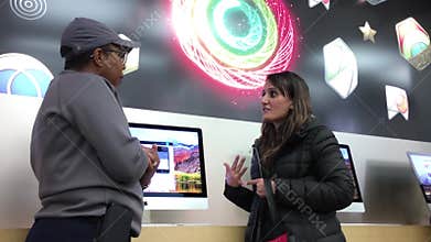 Motion of woman asking questions about iMac inside Apple store