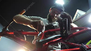 A young mahanic fixing a treadles on a bike. Close-up