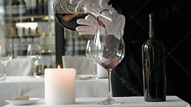 Sommelier stirs red wine in a decanter. Close-up