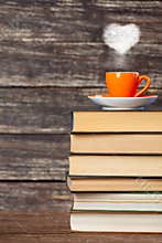 Books pile and cup of coffee with heart shape