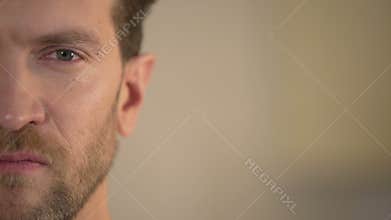 Half face of aggressive man looking with hatred into camera, domestic tyrant