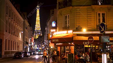Paris, France- Circa August 2017: Parisian cafe at night. Famous french landmark Eiffel Tower
