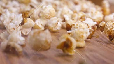 Popcorn falling on authentic wooden table - super slow motion shot