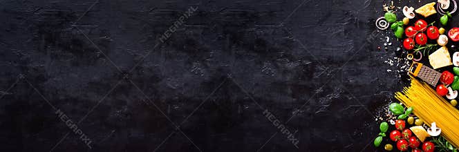 Food ingredients for italian pasta, spaghetti on black stone slate background. Copy space of your text. Banner