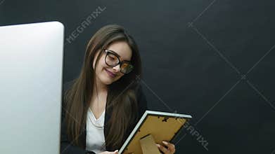 A young woman in the office looks at the photo