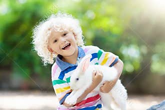 Child with rabbit. Easter bunny. Kids and pets.