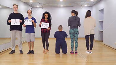 People turns to camera with motivation boards