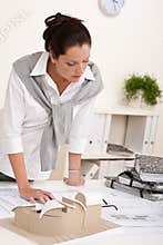 Smiling female architect working with plans