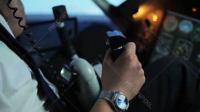 Professional pilot coordinating flight details, talking on radio to controller