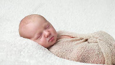 Child napping on a white bedding sheet