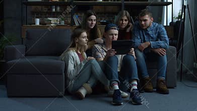 Group of friends watching media content on tablet