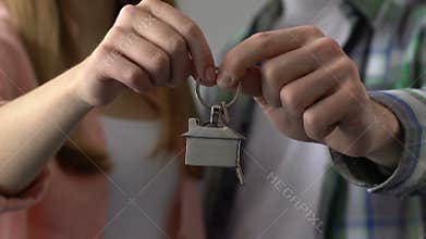 Couple holding key chain house, buying property, mortgage for young family