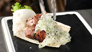 The cook lays roasted meat on a plate