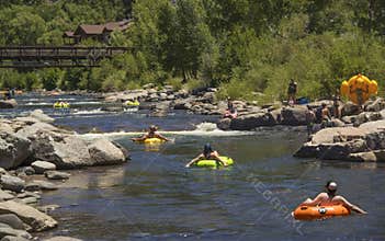 People families having fun cooling off floating in inflatable tubes down the San Juan River on hot summer day in Pagosa Spring