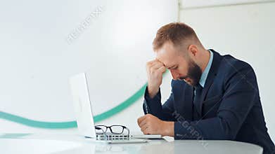Sad and tired businessman sitting in white office