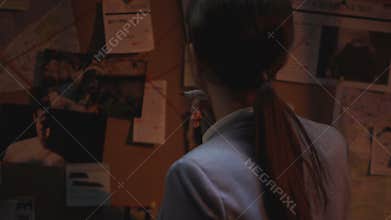 Police specialist making remarks on board with victims photo, figuring out code