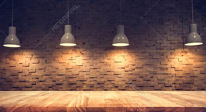 Wood table top on blurred of counter cafe shop with light bulb