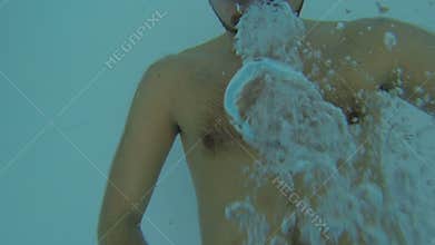 Man falling backwards into pool, holding camera in his hands, diving in and out