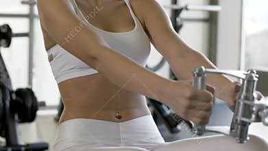 Sports woman pulling weight on fitnes equipment in sports club interior